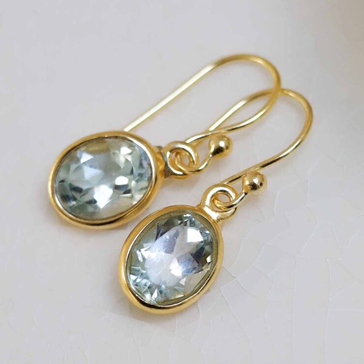 Sterling Silver Gold Plated Dangly Blue Topaz Oval Earrings on white