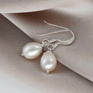 Pearl earrings on folded pink silk