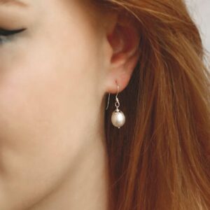 Pearl earrings on model with red hair