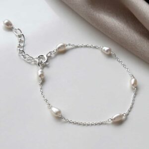 pearl bracelet on white background and pink silk corner detail