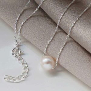 Single Pearl Necklace on silky material background