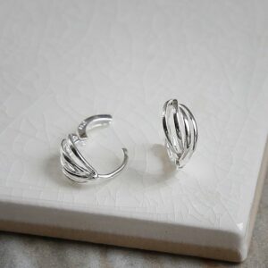 Polished sterling silver braided huggies/ hinged hoop earrings on white background showing one hinged and one un-hinged.