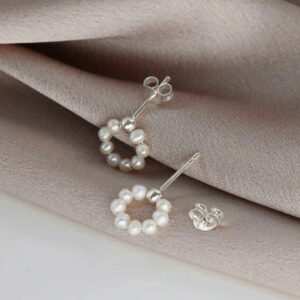 swinging pearl studs on white background with pink silk detail