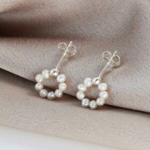 swinging pearl studs on white background with pink silk detail