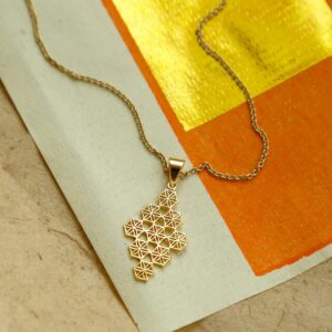 Gold Moroccan Tile Necklace on Orange and Gold Paper background