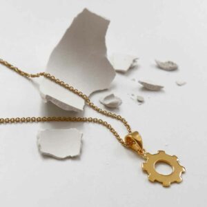 Cog Necklace on broken plaster background