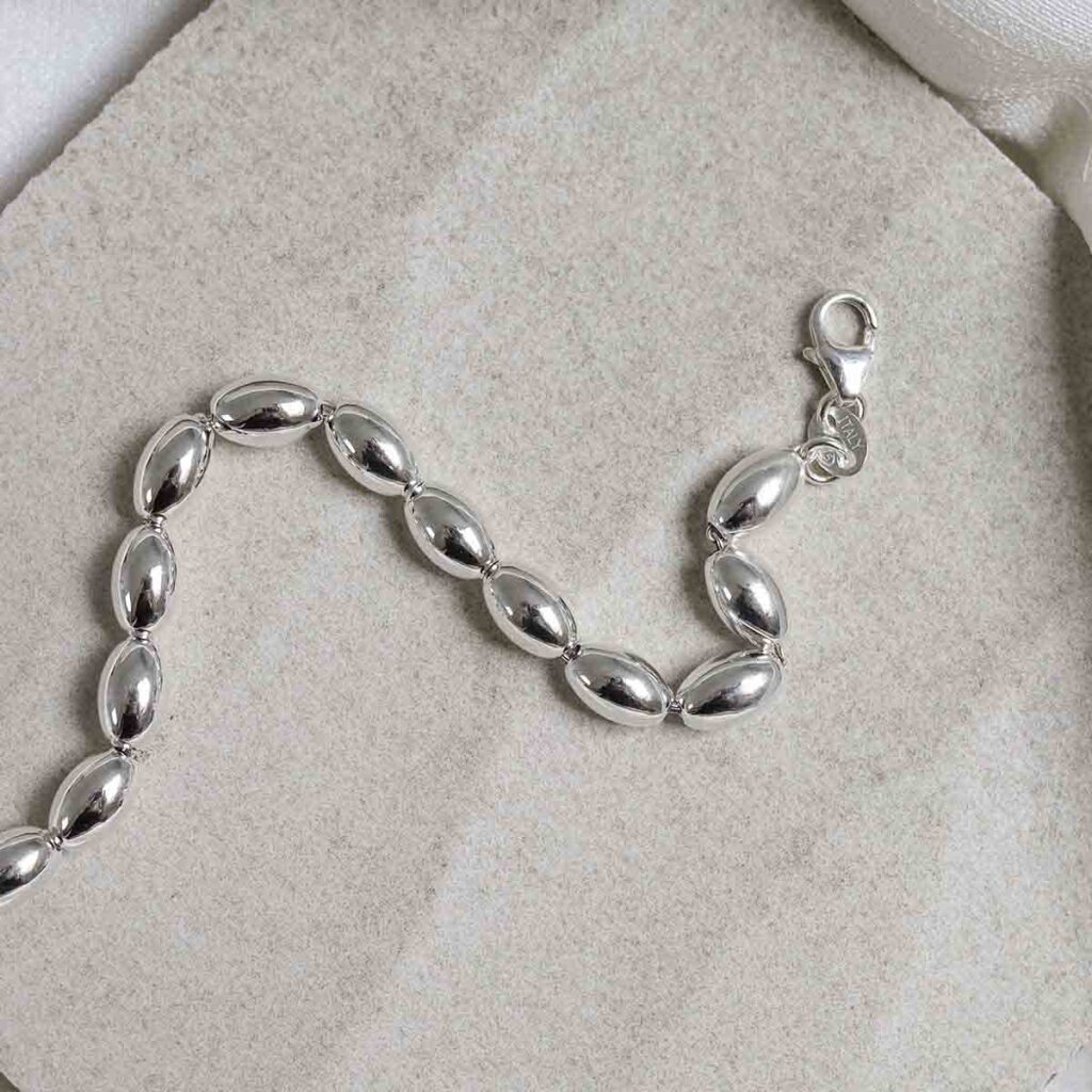 Sterling Silver Oval Beads Bracelet on stone background