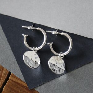 Sterling Silver  Disc Stud Hoops on dark grey triangle. Hammered disc catching light