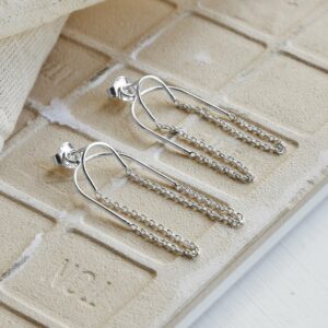 Two way chain Sterling Silver studs on Sandy tile background with canvas