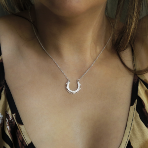 Sterling silver tribal horseshoe necklace on woman wearing leopard print dress..