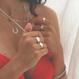 Model wearing engraved oval round small and landscape sterling silver signet rings