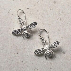 sterling silver dangly bee earrings laid out diagonally