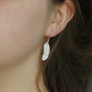 Sterling Silver Feather Drop Earrings Hanging from a ladies ear