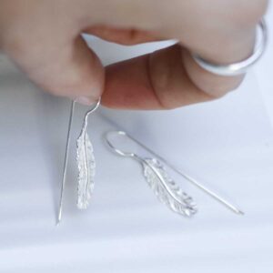 Sterling Silver Feather Drop Earrings in models hand
