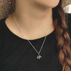 sterling silver origami elephant necklace on model with plaited hair and wearing black tshirt.