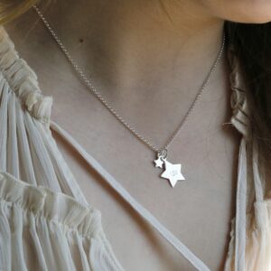 Sterling Silver Double Star Necklace hanging from a girls neck