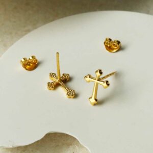 Gold Plated Cross Stud Earrings on curved white background