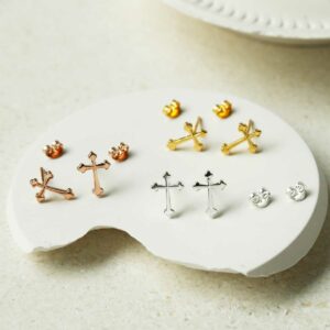 Cross stud earrings in all variations on curvy white background