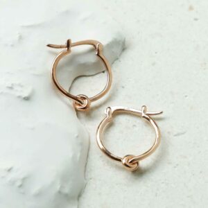 Rose Gold Knot Hoops on white detailed background