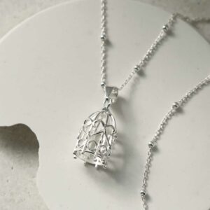 STERLING SILVER BIRDCAGE PENDANT NECKLACE WITH A WHITE BACKGROUND