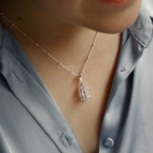 STERLING SILVER BIRDCAGE PENDANT NECKLACE ON MODEL WEARING BLUE SHIRT