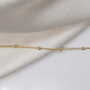 gold plated sterling silver satellite chain laid straight on linen