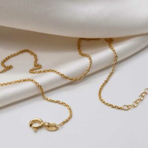 gold plated sterling silver trace chain strewn on linen