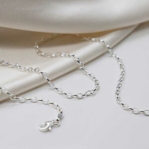 sterling silver oval belcher chain strewn on linen