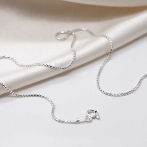 sterling silver round box chain strewn on linen