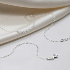 sterling silver trace chain strewn on linen