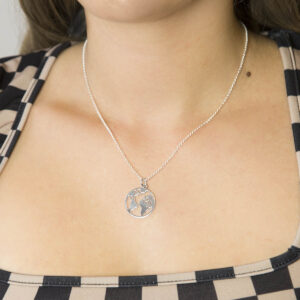 silver planet earth pendant necklace worn by woman