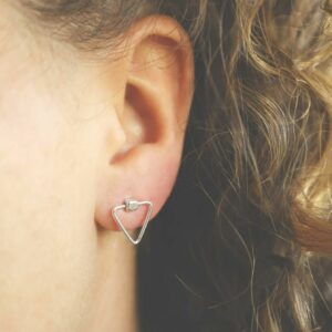 silver plain triangle studs on curly haired model