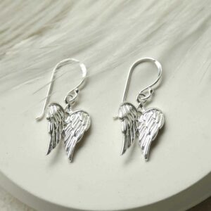 silver attached wings dangly earrings on white feather