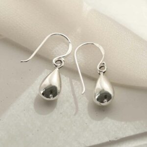 silver teardrop dangly earrings on linen