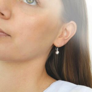 silver single ball dangly earrings on model