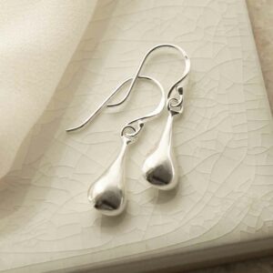 silver small liquid drop dangly earrings laid on tile