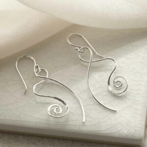 silver spiralling ribbon earrings on tile