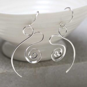 Sterling Silver Twirling Ribbon Dangly Earrings on jewellery dish