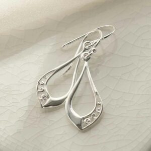 silver swirls in teardrop earrings on tile