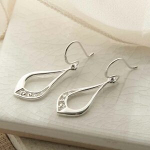 silver swirls in teardrop earrings sideways on tile