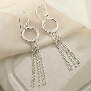 silver tassel on hoop dangly earrings laid on linen