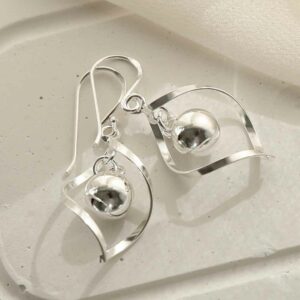 silver twisted earrings with central ball on tile