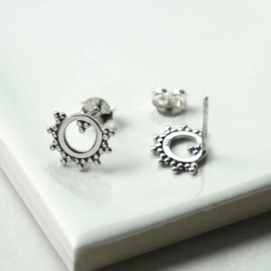 silver beaded circle studs taken apart on tile