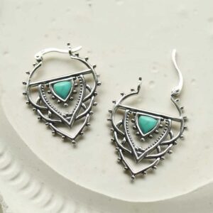 silver exotic hoops with turquoise triangle opened on tile