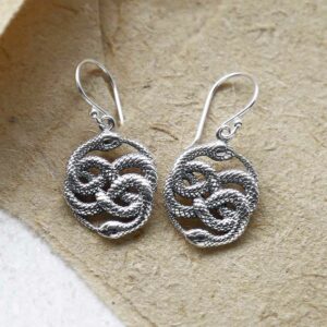 silver twisting snake earrings on brown paper