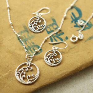 silver frothing waves in circle dangly earrings and necklace set on paper