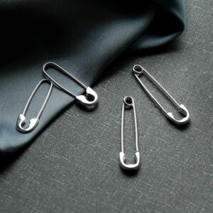 silver small safety pin earrings and large safety pin earrings on silk