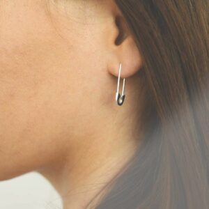 silver safety pin earrings on model