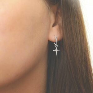 silver glitzy cross hoop studs on model