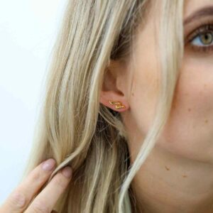 gold flame stud earrings on model